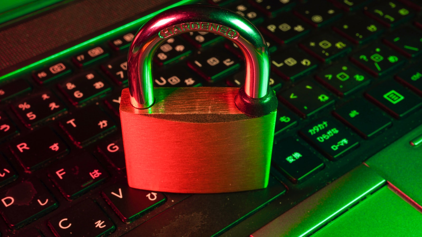Padlock resting on a laptop keyboard lit in red and green