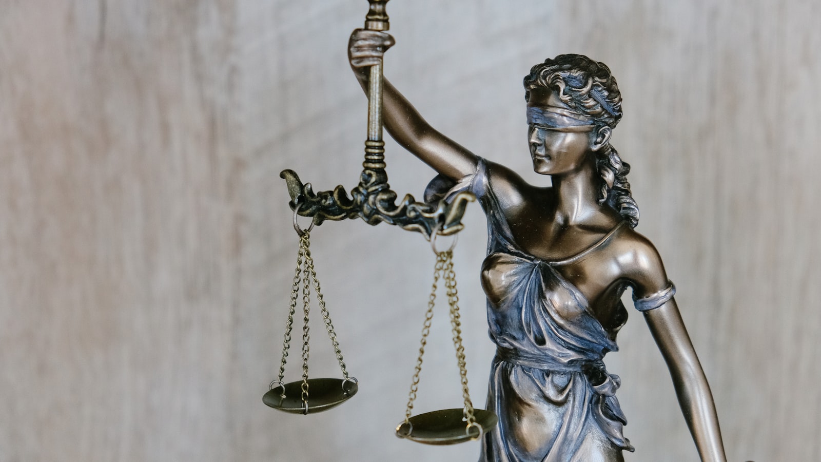Bronze Lady Justice statue holding the scales of justice